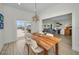Dining space with rustic wood table, stylish light fixture, and views into the living room and waterfront patio at 4381 Poinsettia Dr, St Pete Beach, FL 33706