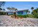 Well-manicured home featuring vibrant landscaping, and a brick driveway at 4381 Poinsettia Dr, St Pete Beach, FL 33706