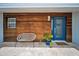 Cozy front porch with wood cladding, seating, and a blue front door at 4381 Poinsettia Dr, St Pete Beach, FL 33706