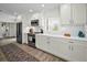 Clean, bright kitchen featuring white cabinets, stainless steel appliances, and subway tile backsplash at 4381 Poinsettia Dr, St Pete Beach, FL 33706