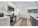Well-lit kitchen with stainless steel range, modern backsplash, and a beautiful painting on the wall at 4381 Poinsettia Dr, St Pete Beach, FL 33706