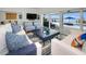 Inviting living room with white sofas, blue patterned chairs, and sliding glass doors showcasing waterfront views at 4381 Poinsettia Dr, St Pete Beach, FL 33706