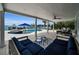 Inviting covered patio featuring stylish blue furniture, ceiling fan and water view at 4381 Poinsettia Dr, St Pete Beach, FL 33706