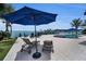 Beautiful patio area with lounge chairs, table, umbrella and stunning water views at 4381 Poinsettia Dr, St Pete Beach, FL 33706