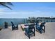 Lovely blue Adirondack chairs gathered around a fire pit with a beautiful water view at 4381 Poinsettia Dr, St Pete Beach, FL 33706