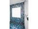 Modern shower featuring blue mosaic tiles, glass block window, and sleek fixtures at 4381 Poinsettia Dr, St Pete Beach, FL 33706