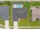Aerial view showcases a home with a screened pool, manicured lawn, and charming neighborhood setting at 4530 Zack Dr, New Port Richey, FL 34653