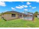 Backyard showcasing the home, a screened pool enclosure, and lush green lawn, ideal for outdoor activities at 4530 Zack Dr, New Port Richey, FL 34653