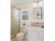 Bathroom featuring a glass-enclosed shower, neutral tile, vanity, and a well-lit mirror at 4530 Zack Dr, New Port Richey, FL 34653