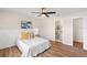 Cozy bedroom featuring a ceiling fan, wood floors, and an adjacent bathroom for added convenience at 4530 Zack Dr, New Port Richey, FL 34653