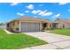 A tan single-story house with a well-manicured lawn and a gray two-car garage at 4530 Zack Dr, New Port Richey, FL 34653