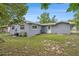 Back exterior of the house with siding, an AC unit, and a backyard at 4570 Essex Ln, Spring Hill, FL 34606
