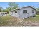 Backyard of the house with a partial view of the back of the house, yard, and fencing at 4570 Essex Ln, Spring Hill, FL 34606