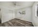 Bright bedroom with wood-look flooring, large window, closet with sliding doors, and ceiling fan at 4570 Essex Ln, Spring Hill, FL 34606