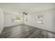 Spacious bedroom with wood-look flooring, three windows and a ceiling fan at 4570 Essex Ln, Spring Hill, FL 34606