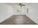 Light and airy bedroom featuring wood-look flooring, two windows and ceiling fan at 4570 Essex Ln, Spring Hill, FL 34606