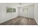 Bright bedroom featuring wood-look flooring, two windows and a ceiling fan at 4570 Essex Ln, Spring Hill, FL 34606
