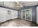 Bonus room with wood-look flooring, white walls, ceiling fan, a back door, and sliding glass door at 4570 Essex Ln, Spring Hill, FL 34606