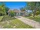 Well-maintained single-story home featuring a carport, manicured lawn, and mature shade trees at 4570 Essex Ln, Spring Hill, FL 34606
