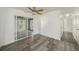 Open-concept room featuring wood flooring, a sliding glass door, and a ceiling fan at 4570 Essex Ln, Spring Hill, FL 34606