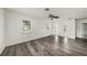 Spacious living room with wood flooring, white walls, and natural light from the windows at 4570 Essex Ln, Spring Hill, FL 34606