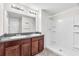 En-suite bathroom with dual vanities, granite counters, updated lights, and a glass enclosed shower at 4902 Grist Mill Ct, Wimauma, FL 33598