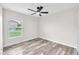 Bright bedroom features wood-look floors and a modern ceiling fan with natural light at 4902 Grist Mill Ct, Wimauma, FL 33598