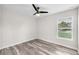 Bright bedroom features wood-look floors and a modern ceiling fan with natural light at 4902 Grist Mill Ct, Wimauma, FL 33598