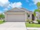 Charming single-story home featuring a two-car garage, neutral paint, and a well-manicured lawn at 4902 Grist Mill Ct, Wimauma, FL 33598