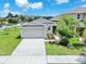 Well maintained single-Gathering home with a two-car garage, manicured lawn, and lush landscaping at 4902 Grist Mill Ct, Wimauma, FL 33598