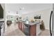 Open kitchen island with seating, showcasing modern appliances and seamless flow into the living area at 4902 Grist Mill Ct, Wimauma, FL 33598