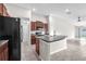 Eat-in kitchen with black appliances, brown cabinets, granite countertops, and grey tile flooring at 4902 Grist Mill Ct, Wimauma, FL 33598