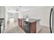 Eat-in kitchen with black appliances, brown cabinets, granite countertops, and grey tile flooring at 4902 Grist Mill Ct, Wimauma, FL 33598