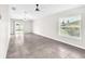 Open living room with neutral paint, fan, grey tile floor, and sliding glass doors to backyard at 4902 Grist Mill Ct, Wimauma, FL 33598