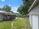This backyard features a screened-in patio, a shed, mature trees, and solar panels on the roof at 4906 Presidential St, Seffner, FL 33584