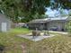 This backyard offers a patio with seating, mature trees, and solar panels on the roof at 4906 Presidential St, Seffner, FL 33584