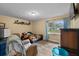 Comfortable bedroom featuring wood-look floors, a window with curtains, and a sunflower comforter at 4906 Presidential St, Seffner, FL 33584