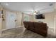 View of living room with wood-look tile, ceiling fan, and leather reclining sofa at 4906 Presidential St, Seffner, FL 33584