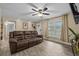 View of living room with wood-look tile, ceiling fan, and leather reclining sofa at 4906 Presidential St, Seffner, FL 33584