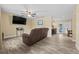 View of living room with wood-look tile, ceiling fan, and leather reclining sofa at 4906 Presidential St, Seffner, FL 33584