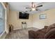 View of living room with wood-look tile, ceiling fan, and leather reclining sofa at 4906 Presidential St, Seffner, FL 33584