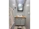 Bathroom vanity featuring white cabinets, wood countertop, sink, and mirror cabinet at 5248 Antigua Dr, Zephyrhills, FL 33541
