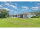 Expansive backyard featuring a screened lanai, lush lawn, and mature trees, ideal for relaxation and entertainment at 5814 Heronpark Pl, Lithia, FL 33547