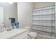 Bright bathroom featuring a white vanity, toilet, and a shower with a gray and white striped curtain at 5814 Heronpark Pl, Lithia, FL 33547