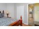 A cozy bedroom features a wood-trimmed bed, closet, and a glimpse of the kitchen, offering warmth and functionality at 5814 Heronpark Pl, Lithia, FL 33547