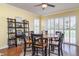 Bright dining area with a round wood table, seating for six, and modern shuttered windows at 5814 Heronpark Pl, Lithia, FL 33547