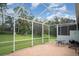 Spacious screened lanai with brick patio, table, grill, and lush green backyard, perfect for outdoor enjoyment at 5814 Heronpark Pl, Lithia, FL 33547