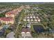 Aerial view of a light gray two-story home with brown roof near an assortment of buildings and trees at 6602 S Sherrill St, Tampa, FL 33616