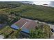 An aerial view of a light gray two-story home with brown roof near an assortment of buildings at 6602 S Sherrill St, Tampa, FL 33616