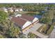 An aerial view of a light gray two-story home with a brown roof and a nearby pond at 6602 S Sherrill St, Tampa, FL 33616